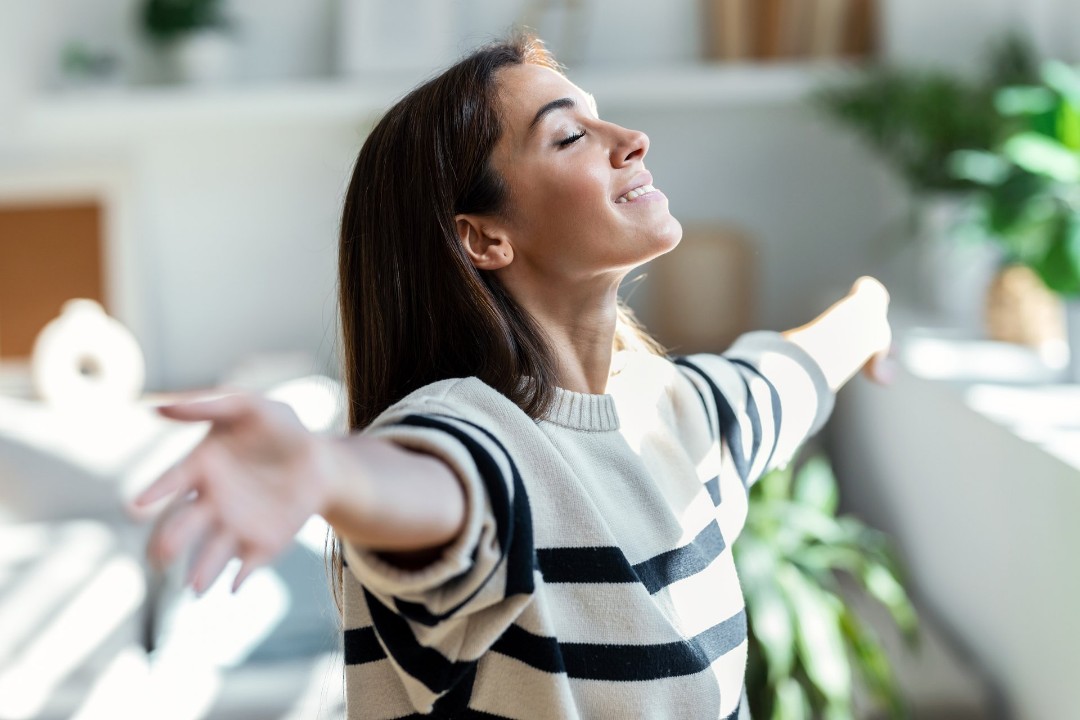Woman taking a deep breath after receiving professional air duct cleaning