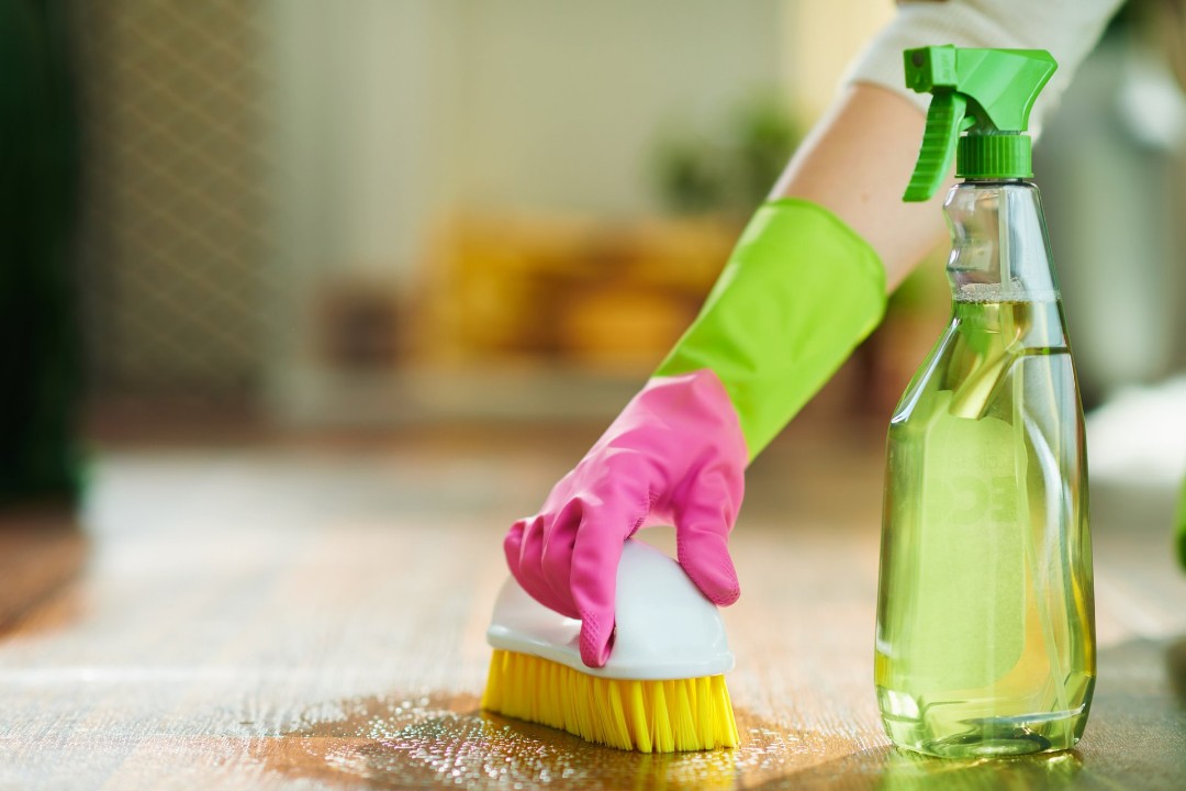 Female using eco-friendly hardwood floor cleaner product