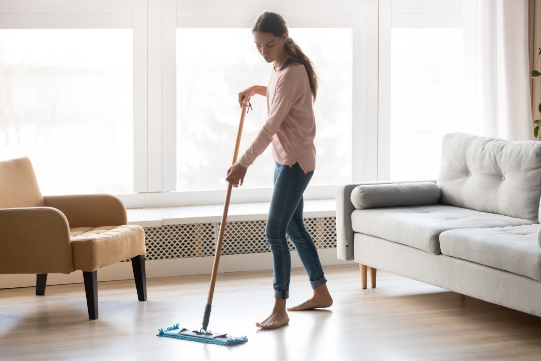 Female using a microfiber mop to clean laminate flooring